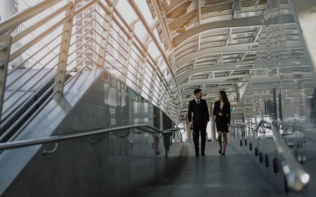 Two business professionals walking through a modern office complex