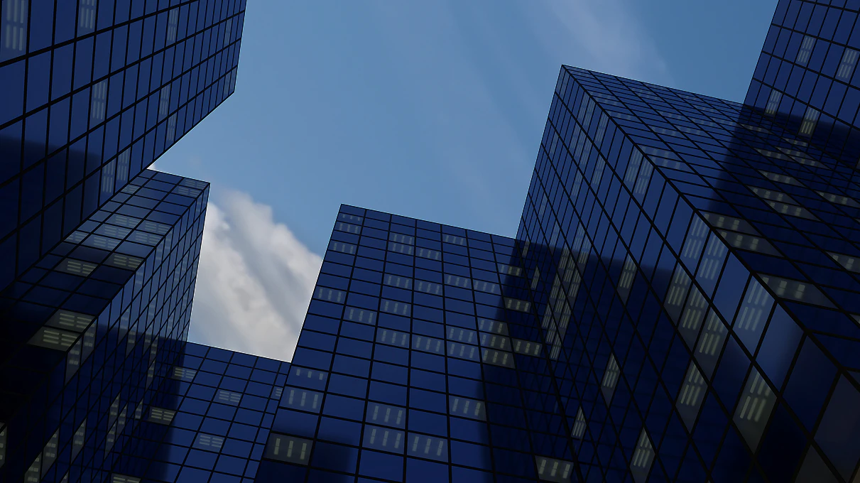 Modern glass office buildings viewed against a blue sky